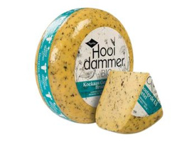 KI generiert: Ein runder Laib Hooi dammer BIO Käse mit einem angeschnittenen Stück.