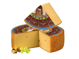 KI generiert: Das Bild zeigt ein großes Käsestück mit einem herausgeschnittenen Teil, wodurch die gelbliche Innenstruktur sichtbar wird. Der Hauptinhalt des Bildes ist der Käse.