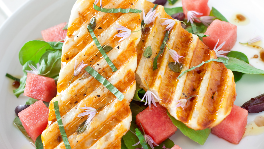 KI generiert: Das Bild zeigt eine Schüssel mit einem bunten Salat aus Rote-Bete-Scheiben, Karottenstreifen, Feldsalat, gehackten Nüssen und einem Klecks Sahne oder Joghurt in der Mitte. Der Salat liegt auf einem Holztisch.