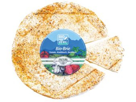 KI generiert: Das Bild zeigt einen runden Laib Bio-Brie mit einem ausgeschnittenen Stück. Text: "BIO BERG, Bio-Brie, Tomate, Knoblauch, Basilikum".