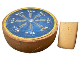 KI generiert: Ein ganzer Laib und ein Stück Käse mit blauem Etikett "Adelberger".