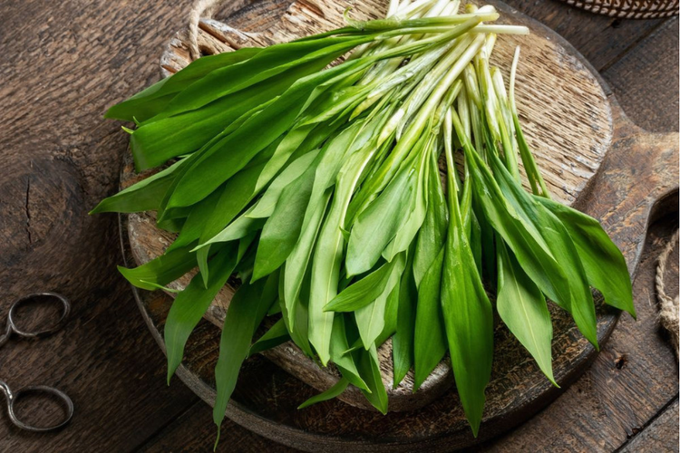 KI generiert: Ein Bund frischer Bärlauch auf einem hölzernen Schneidebrett.