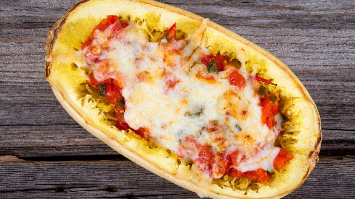 KI generiert: Das Bild zeigt eine Schüssel mit einem bunten Salat aus Rote-Bete-Scheiben, Karottenstreifen, Feldsalat, gehackten Nüssen und einem Klecks Sahne oder Joghurt in der Mitte. Der Salat liegt auf einem Holztisch.