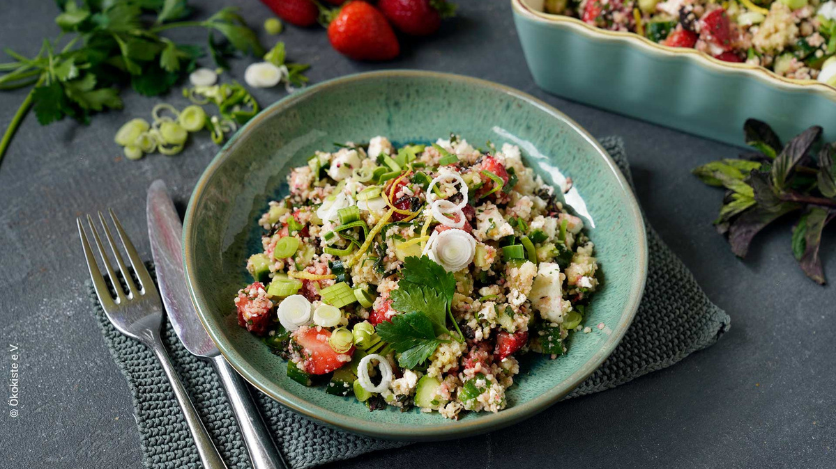 KI generiert: Das Bild zeigt eine Schüssel mit einem bunten Salat aus Rote-Bete-Scheiben, Karottenstreifen, Feldsalat, gehackten Nüssen und einem Klecks Sahne oder Joghurt in der Mitte. Der Salat liegt auf einem Holztisch.