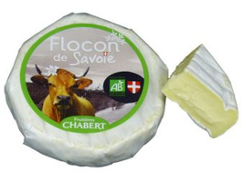 KI generiert: Kleiner Weichkäse mit Etikett "Flocon de Savoie", daneben ein angeschnittenes Stück.
