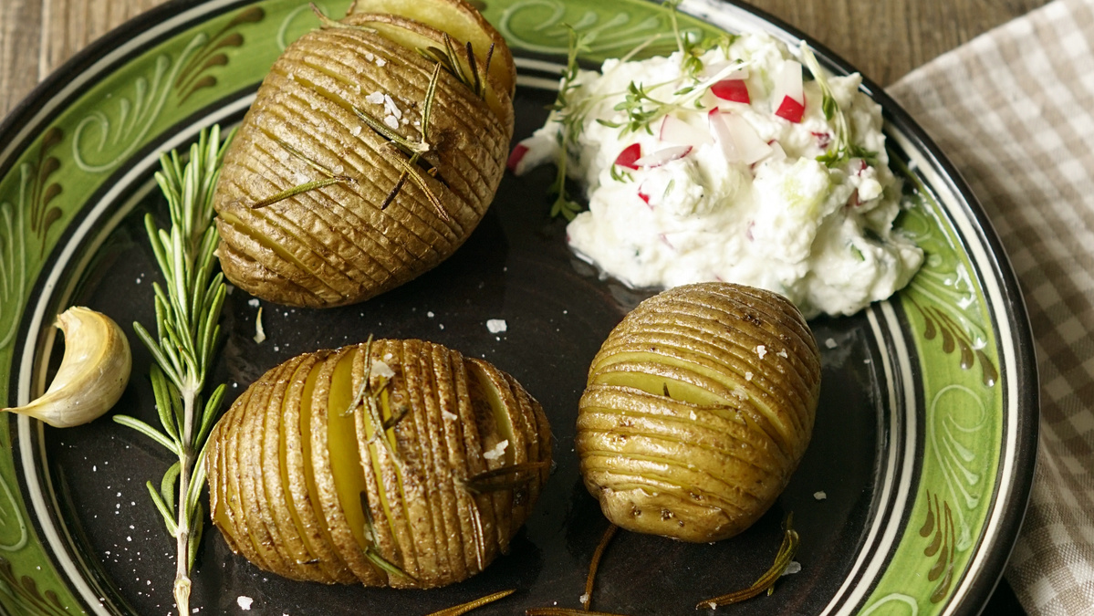 KI generiert: Das Bild zeigt eine Schüssel mit einem bunten Salat aus Rote-Bete-Scheiben, Karottenstreifen, Feldsalat, gehackten Nüssen und einem Klecks Sahne oder Joghurt in der Mitte. Der Salat liegt auf einem Holztisch.