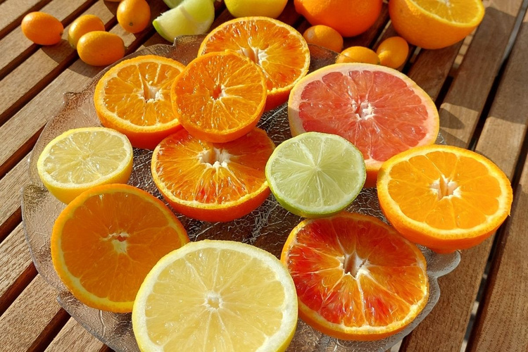 KI generiert: Ein Teller mit verschiedenen geschnittenen Zitrusfrüchten auf einem Holztisch.