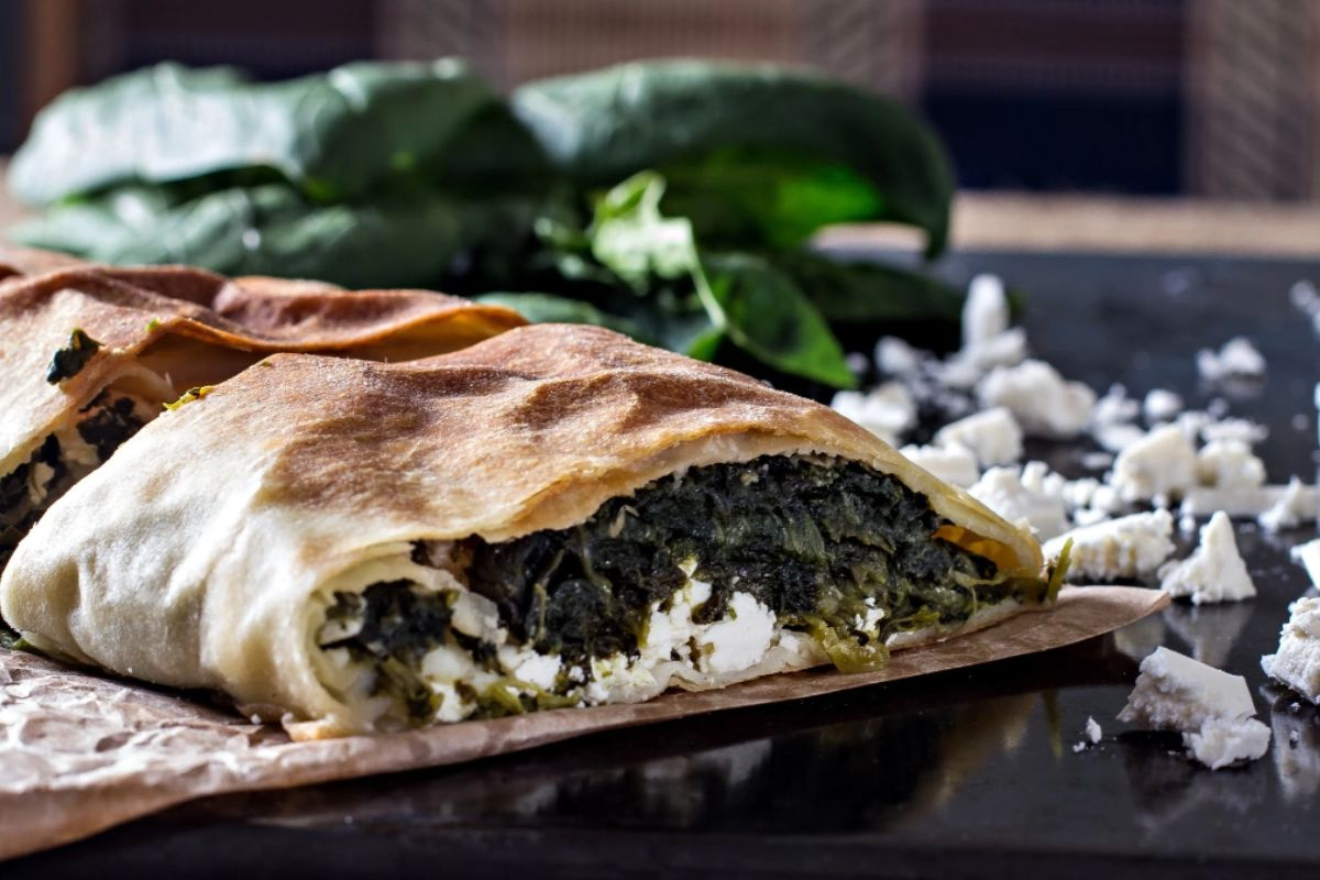 KI generiert: Das Bild zeigt eine Schüssel mit einem bunten Salat aus Rote-Bete-Scheiben, Karottenstreifen, Feldsalat, gehackten Nüssen und einem Klecks Sahne oder Joghurt in der Mitte. Der Salat liegt auf einem Holztisch.