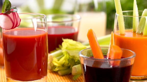 KI generiert: Mehrere Gläser mit frischen Gemüse-Säften, garniert mit Sellerie, Möhren und Radieschenstäbchen.