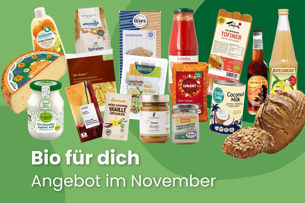 KI generiert: Das Bild zeigt zwei Personen in grüner Arbeitskleidung, die lächelnd eine Kiste mit frischem Obst und Gemüse halten. Im Hintergrund sind weitere Kisten mit Tomaten, Äpfeln und Salat zu sehen, was auf ein Lager oder eine Verkaufsstelle für frische Lebensmittel hinweist.