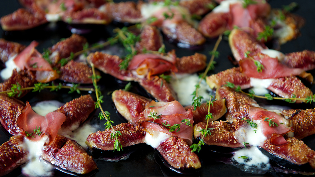 KI generiert: Das Bild zeigt eine Schüssel mit einem bunten Salat aus Rote-Bete-Scheiben, Karottenstreifen, Feldsalat, gehackten Nüssen und einem Klecks Sahne oder Joghurt in der Mitte. Der Salat liegt auf einem Holztisch.