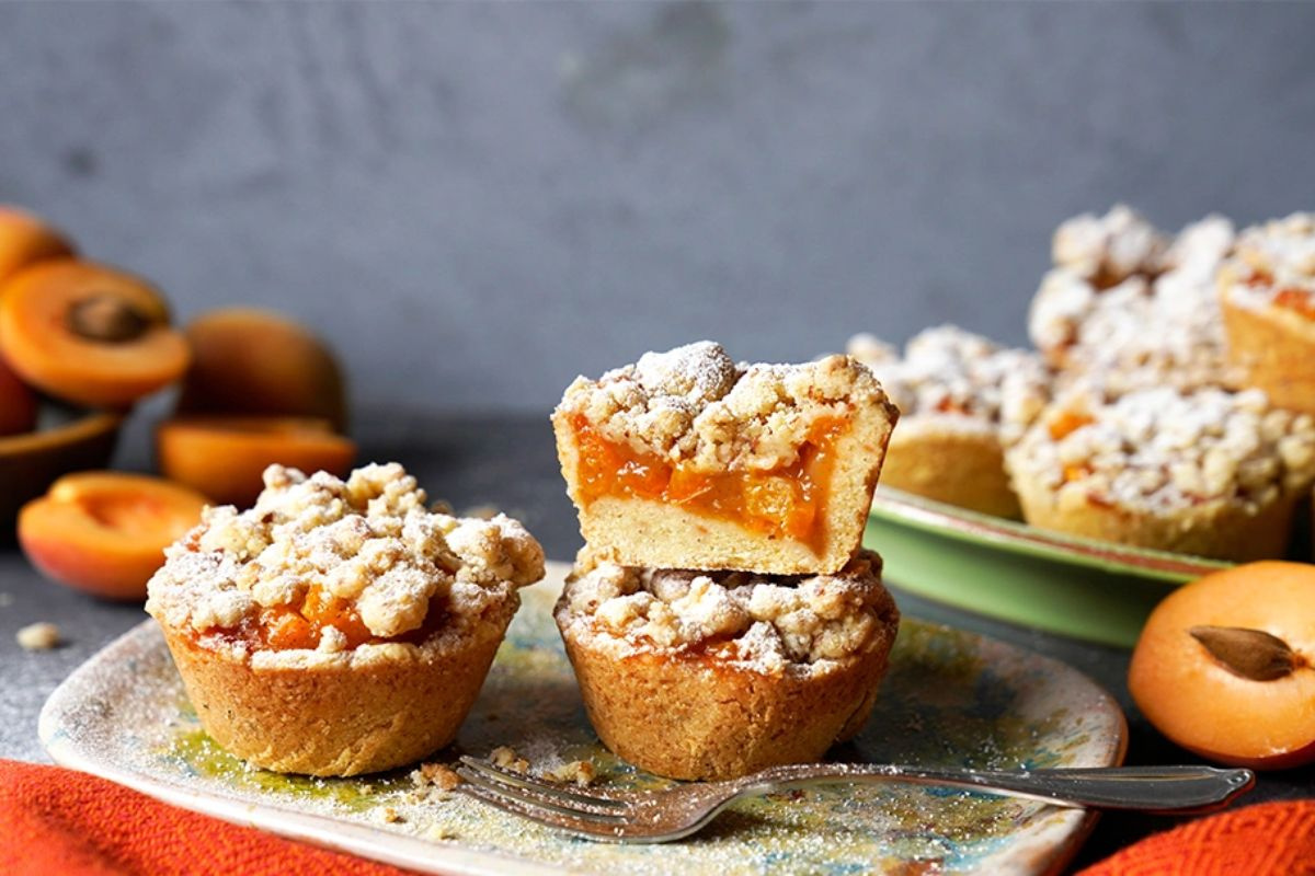 KI generiert: Das Bild zeigt eine Schüssel mit einem bunten Salat aus Rote-Bete-Scheiben, Karottenstreifen, Feldsalat, gehackten Nüssen und einem Klecks Sahne oder Joghurt in der Mitte. Der Salat liegt auf einem Holztisch.