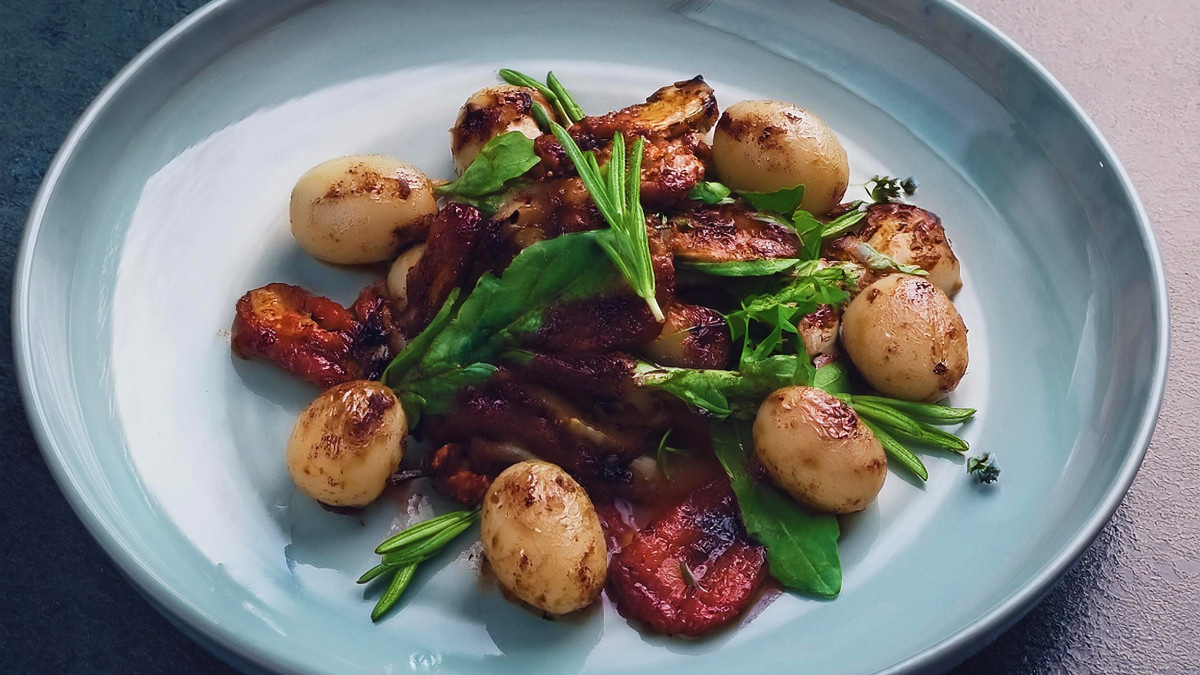 KI generiert: Das Bild zeigt eine Schüssel mit einem bunten Salat aus Rote-Bete-Scheiben, Karottenstreifen, Feldsalat, gehackten Nüssen und einem Klecks Sahne oder Joghurt in der Mitte. Der Salat liegt auf einem Holztisch.