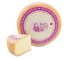 KI generiert: Ein Laib Käse mit einem Stück abgeschnitten. Text: "Bio Schaukäserei Wiggensbach".