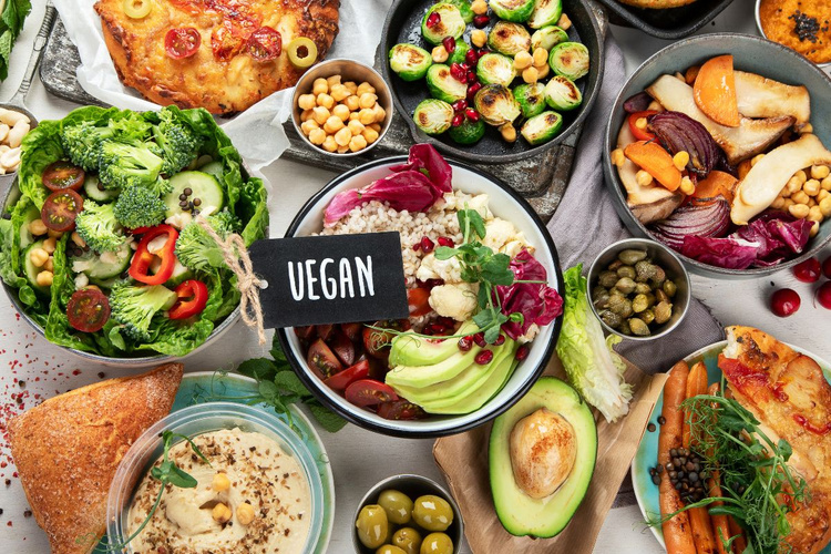 KI generiert: Eine Vielfalt an veganem Essen mit einem "VEGAN"-Schild in der Mitte.