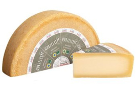 KI generiert: Eine halbe Käselaibe und ein Käsestück. Text: "MÜNSTERSEER".