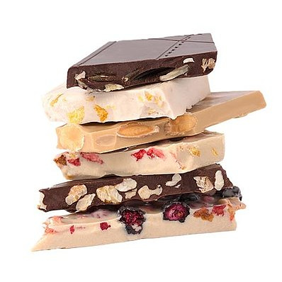 KI generiert: Ein Stapel bunter Schokoladentafeln mit verschiedenen Zutaten wie Nüssen und getrockneten Früchten.