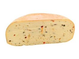 KI generiert: Ein halbes Stück Käse mit Kräutern und Gewürzen durchzogen.