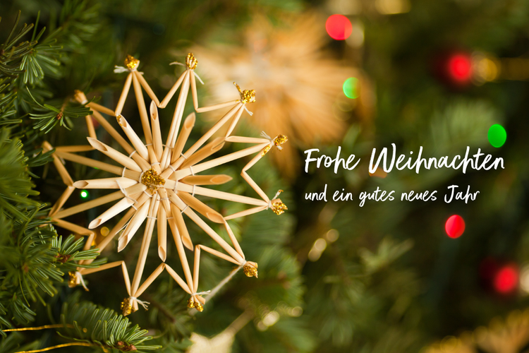 KI generiert: Weihnachtsdekoration mit Strohstern und Schriftzug: "Frohe Weihnachten und ein gutes neues Jahr".