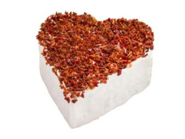 KI generiert: Ein herzförmiger Weichkäse mit getrockneten roten Blüten bedeckt.