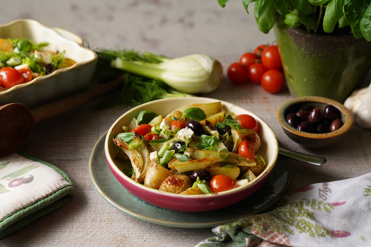 KI generiert: Das Bild zeigt eine Schüssel mit einem bunten Salat aus Rote-Bete-Scheiben, Karottenstreifen, Feldsalat, gehackten Nüssen und einem Klecks Sahne oder Joghurt in der Mitte. Der Salat liegt auf einem Holztisch.