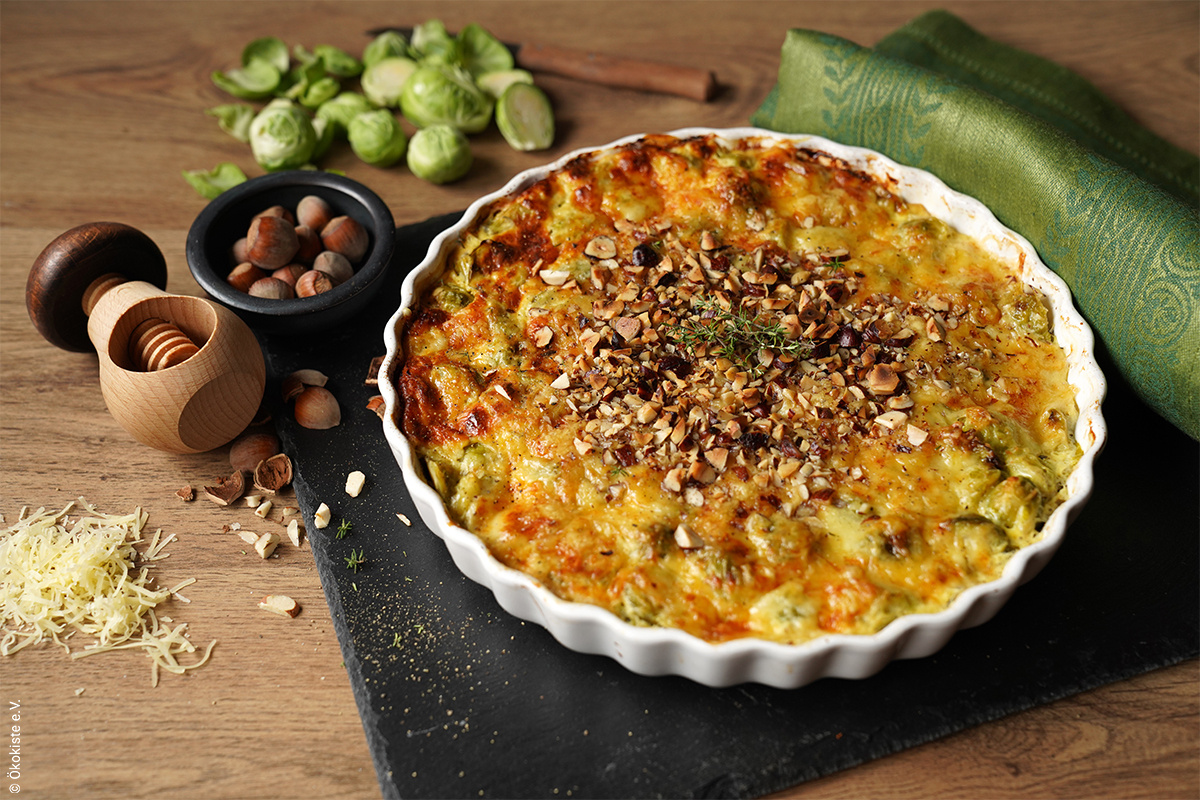 KI generiert: Das Bild zeigt eine Schüssel mit einem bunten Salat aus Rote-Bete-Scheiben, Karottenstreifen, Feldsalat, gehackten Nüssen und einem Klecks Sahne oder Joghurt in der Mitte. Der Salat liegt auf einem Holztisch.