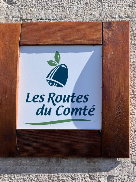 KI generiert: Ein Schild mit der Aufschrift "Les Routes du Comté" und einem Käsemotiv.
