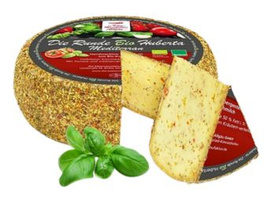 KI generiert: Ein runder Laib Käse mit Kräuterkruste, ein angeschnittenes Stück und Basilikum. Text: "Die Runde Bio Hubert".