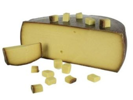 KI generiert: Ein angeschnittener Käselaib und Käsestücke auf weißem Hintergrund.