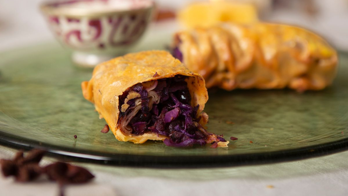 KI generiert: Das Bild zeigt eine Schüssel mit einem bunten Salat aus Rote-Bete-Scheiben, Karottenstreifen, Feldsalat, gehackten Nüssen und einem Klecks Sahne oder Joghurt in der Mitte. Der Salat liegt auf einem Holztisch.
