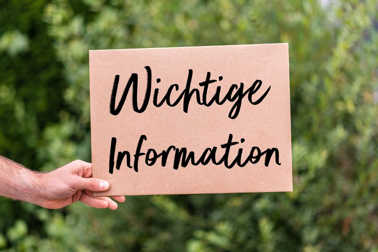 KI generiert: Person hält ein Schild mit dem Text "Wichtige Information" vor einer grünen, unscharfen Pflanzenkulisse.