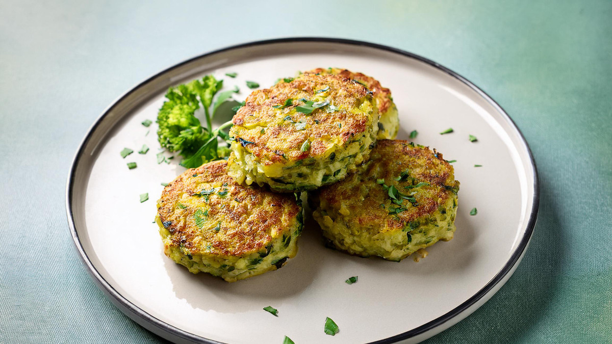 KI generiert: Das Bild zeigt eine Schüssel mit einem bunten Salat aus Rote-Bete-Scheiben, Karottenstreifen, Feldsalat, gehackten Nüssen und einem Klecks Sahne oder Joghurt in der Mitte. Der Salat liegt auf einem Holztisch.