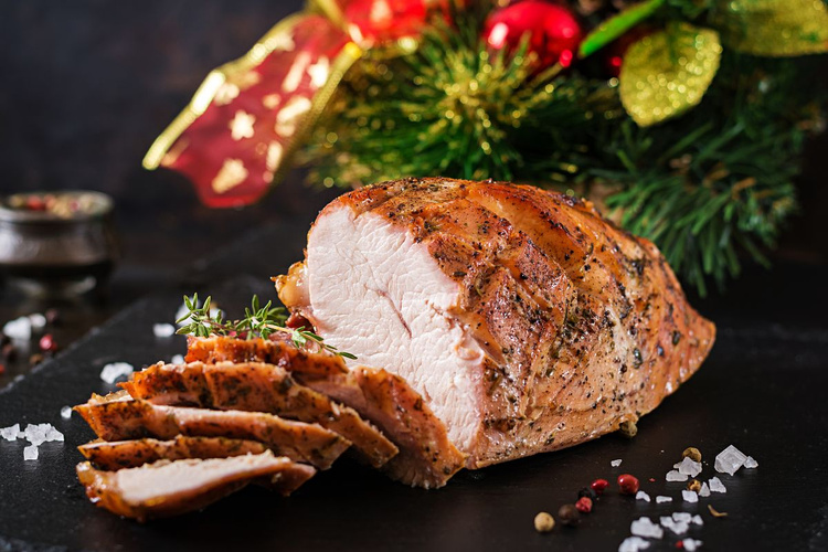 KI generiert: Ein gewürzter Braten auf einem Tisch, dekoriert mit Weihnachtsdekoration im Hintergrund.