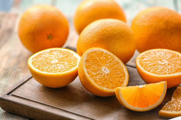 KI generiert: Orangen auf einem Holzbrett, einige sind halbiert, andere ganz.