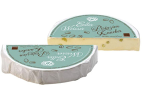 KI generiert: Zwei Käsestücke mit Pistazien, Text: "Edler Weisser Pistazien Knacker, Bioland".