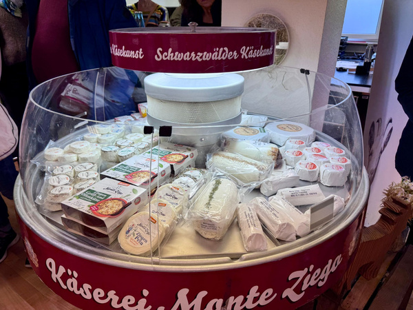 KI generiert: Käsetheke mit verschiedenen Käsesorten, darüber der Text: "Schwarzwälder Käsekunst".