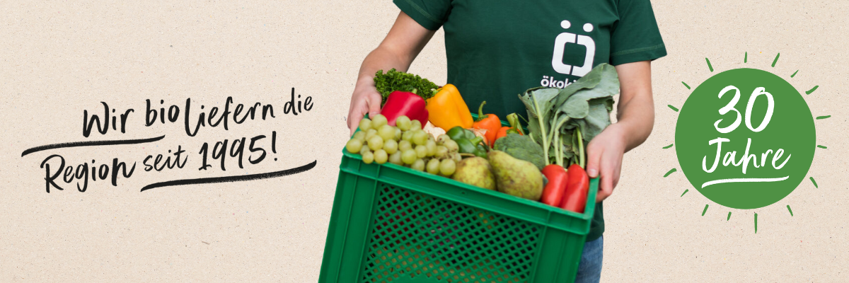 KI generiert: Das Bild zeigt eine Person, die einen Korb mit frischem Obst und Gemüse hält. Daneben befindet sich der Text "Wir bio liefern die Region seit 1995" und ein Hinweis auf das 30-jährige Jubiläum.