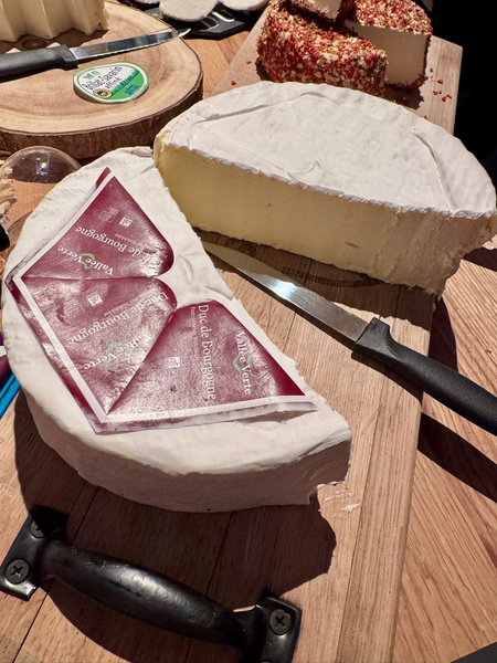 KI generiert: Große Käselaibe auf Holzbrett mit Messern, Etikett: "ValléVerte Duc de bourgogne".