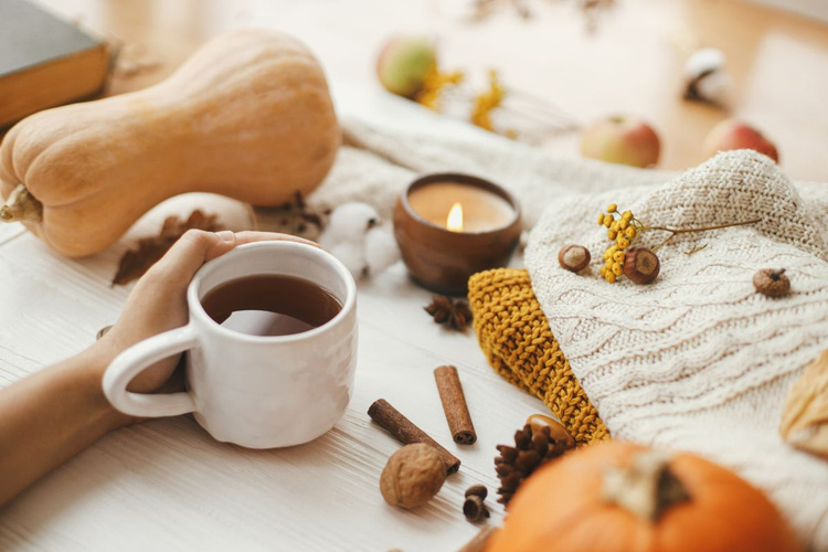 KI generiert: Das Bild zeigt eine Tasse Kaffee mit Zimtstange und Gewürzen auf einem Holztisch.