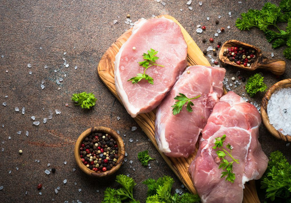 KI generiert: Das Bild zeigt zwei Personen in grüner Arbeitskleidung, die lächelnd eine Kiste mit frischem Obst und Gemüse halten. Im Hintergrund sind weitere Kisten mit Tomaten, Äpfeln und Salat zu sehen, was auf ein Lager oder eine Verkaufsstelle für frische Lebensmittel hinweist.