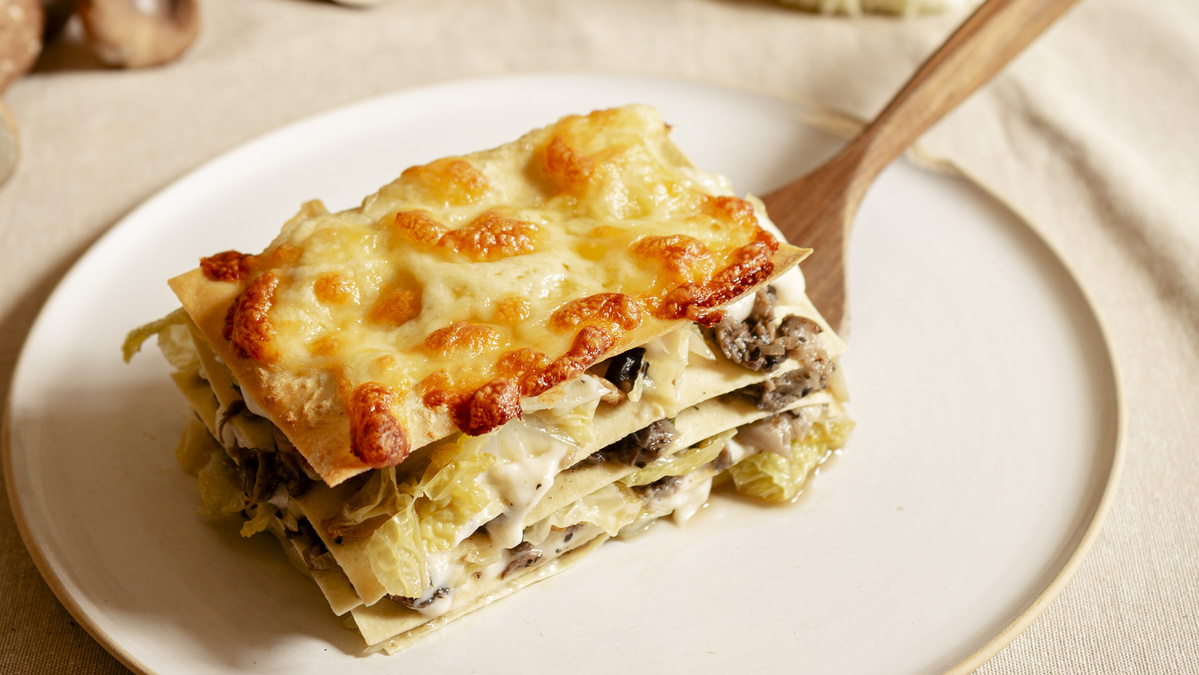 KI generiert: Das Bild zeigt eine Schüssel mit einem bunten Salat aus Rote-Bete-Scheiben, Karottenstreifen, Feldsalat, gehackten Nüssen und einem Klecks Sahne oder Joghurt in der Mitte. Der Salat liegt auf einem Holztisch.