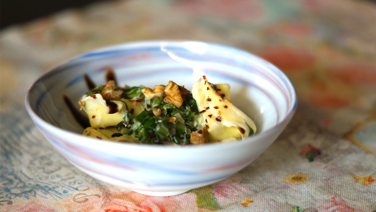 KI generiert: Das Bild zeigt eine Schüssel mit einem bunten Salat aus Rote-Bete-Scheiben, Karottenstreifen, Feldsalat, gehackten Nüssen und einem Klecks Sahne oder Joghurt in der Mitte. Der Salat liegt auf einem Holztisch.