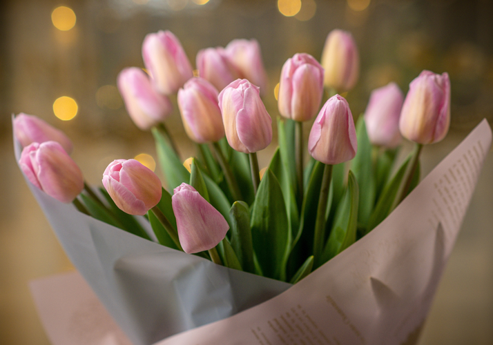 KI generiert: Ein Strauß rosa Tulpen in einer dekorativen Verpackung.