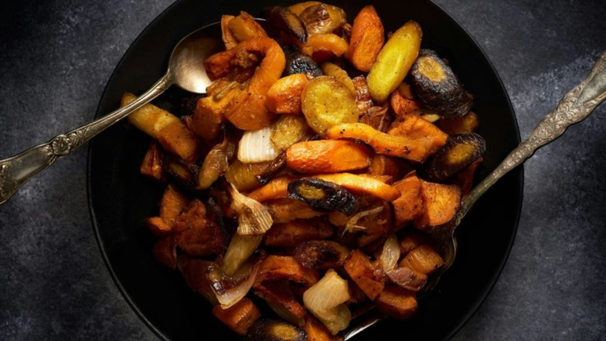 KI generiert: Das Bild zeigt eine Schüssel mit einem bunten Salat aus Rote-Bete-Scheiben, Karottenstreifen, Feldsalat, gehackten Nüssen und einem Klecks Sahne oder Joghurt in der Mitte. Der Salat liegt auf einem Holztisch.