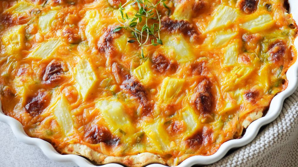 KI generiert: Das Bild zeigt eine Schüssel mit einem bunten Salat aus Rote-Bete-Scheiben, Karottenstreifen, Feldsalat, gehackten Nüssen und einem Klecks Sahne oder Joghurt in der Mitte. Der Salat liegt auf einem Holztisch.