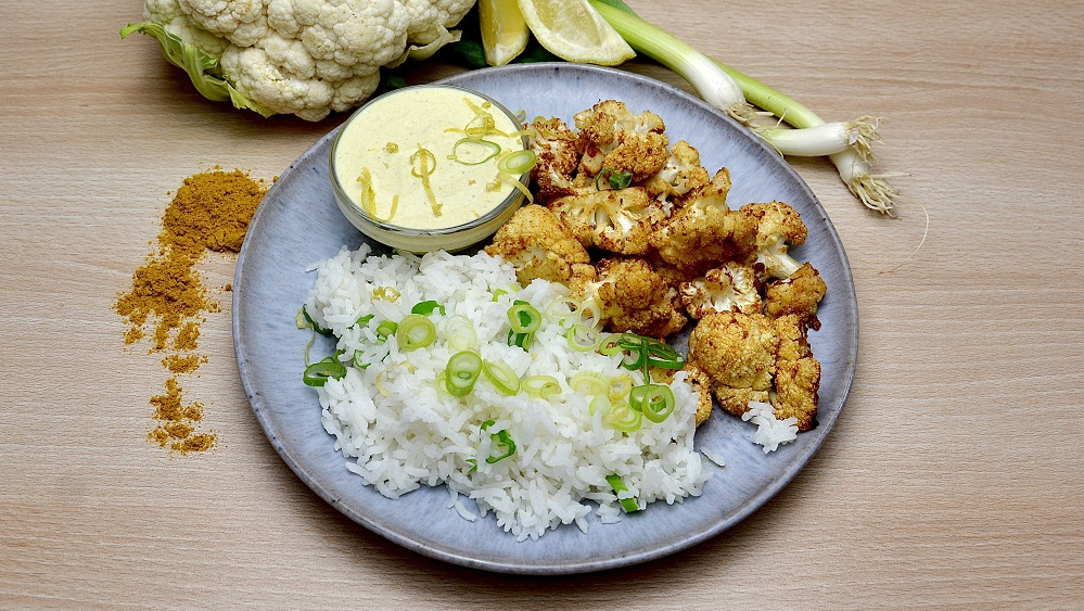 KI generiert: Das Bild zeigt eine Schüssel mit einem bunten Salat aus Rote-Bete-Scheiben, Karottenstreifen, Feldsalat, gehackten Nüssen und einem Klecks Sahne oder Joghurt in der Mitte. Der Salat liegt auf einem Holztisch.